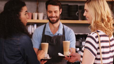 waiter and customers having coffee at counter