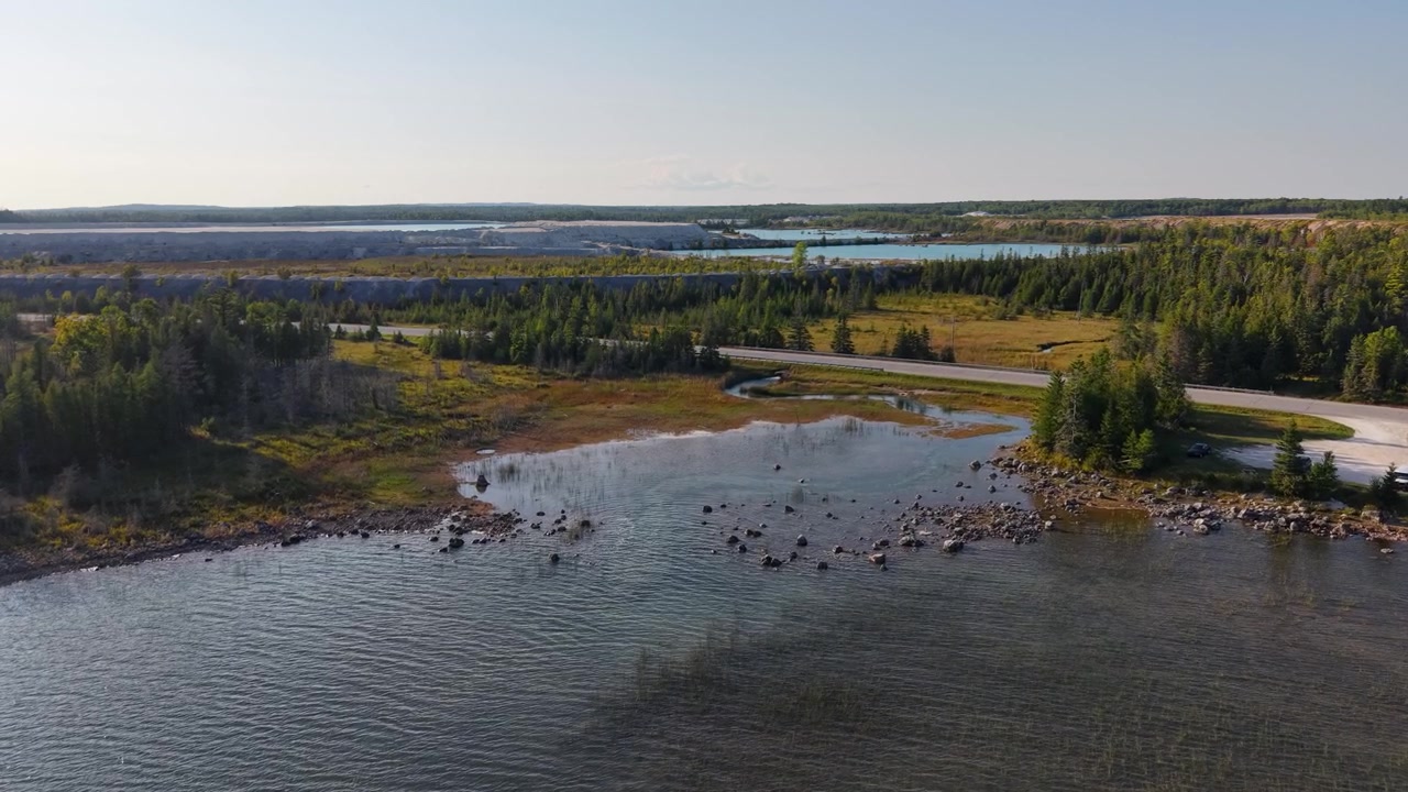 Luftfoto af en sø og skovklædt ø i Hessel, Michigan, med Lake Huron synlig.