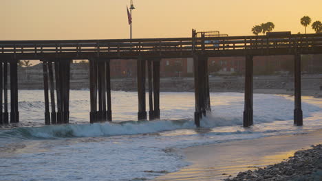 Schwenk-Auf-Den-Ventura-Pier-Mit-Leuchtend-Orangefarbenem-Sonnenuntergang-Im-Hintergrund-In-Südkalifornien