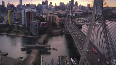 peak hour and rush hour traffic travelling over a suspended bridge into a downtown district