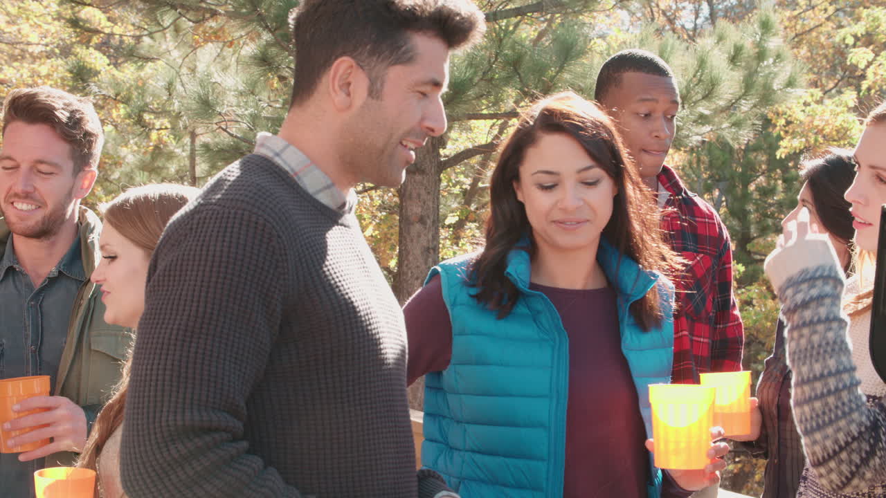 친구들이 바베큐에서 얘기하고, 한 명이  ⁇ 고, 가 ⁇ 게