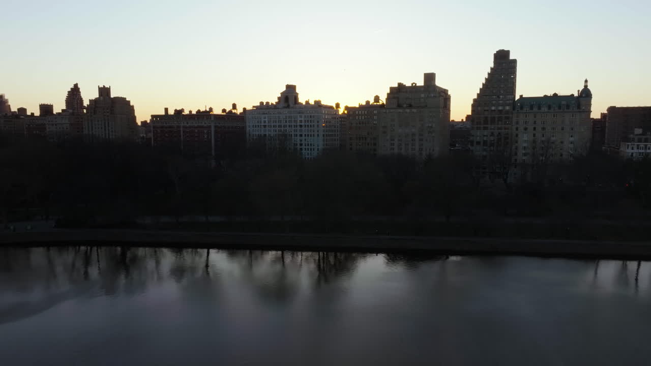 drone filmado sobre el embalse del parque central revelando el sol de la tarde sobre el upper east side, manhattan, nueva york