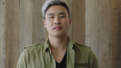 portrait of young confident asian man looking serious at camera turns head pensive thinking