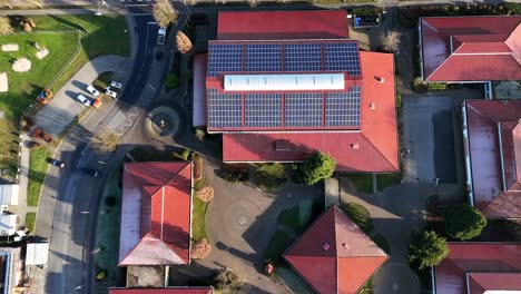 solar panels on roof of school during frosty and sunny day in school. aerial top down flyover shot. modern school in winter season.