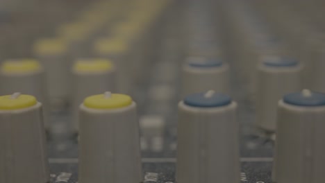 Extreme-close-up-of-gray-sound-mixer-knobs-in-a-recording-studio