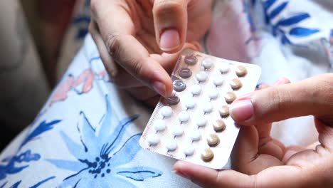 woman holding birth control pills
