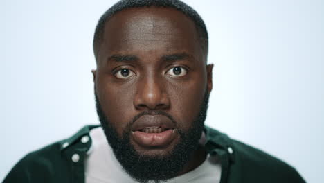 Portrait-of-angry-african-american-man-screaming-in-light-background-in-studio.