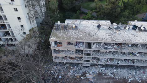 low-altitude drone pans and rotates around a bombed residential building in tel aviv.