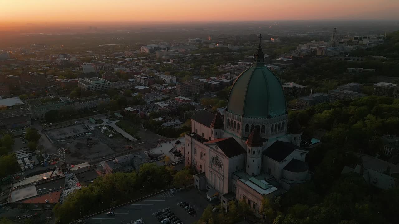 Aerial shot revealing the Saint Joseph Oratory and Montreal suburbs at sunset during summer season, Montreal city, Quebec region, Canada