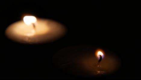 two burning candles in the dark