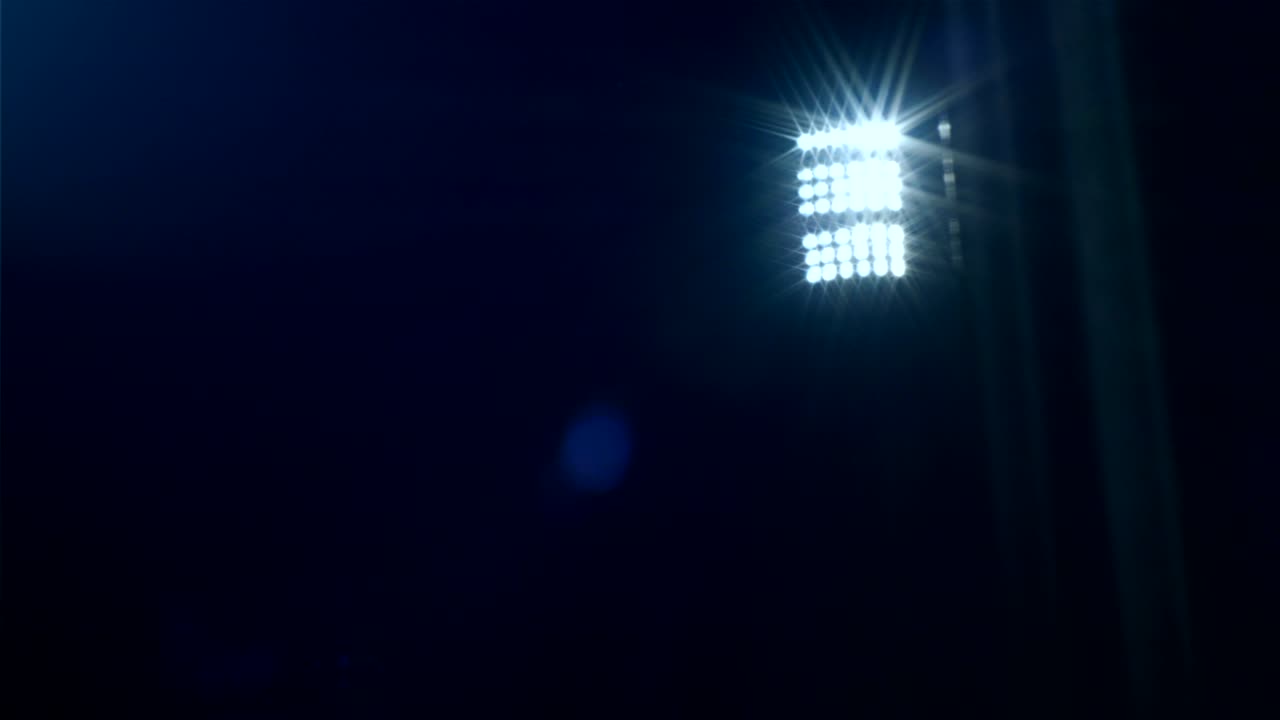 tomada de dolly que revela las luces del estadio de fútbol contra el cielo oscuro, 4k