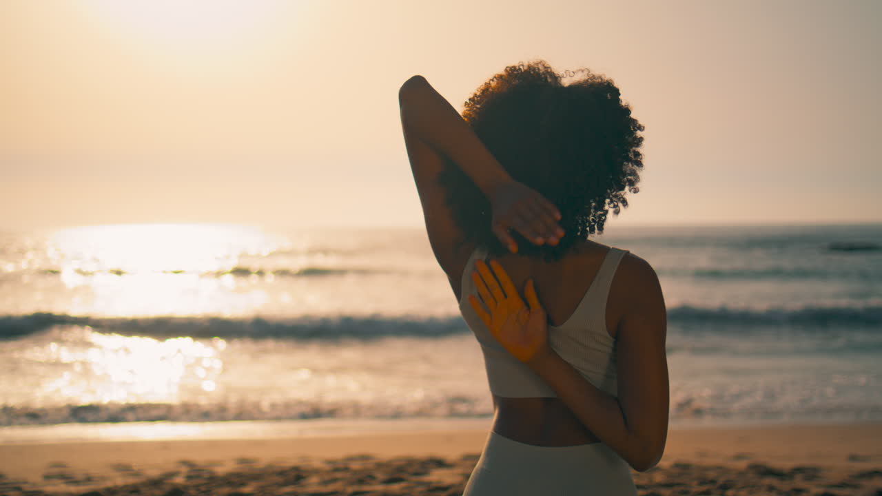Yoga girl practicing gomukhasana on beach closeup. Woman stretching arms sunrise