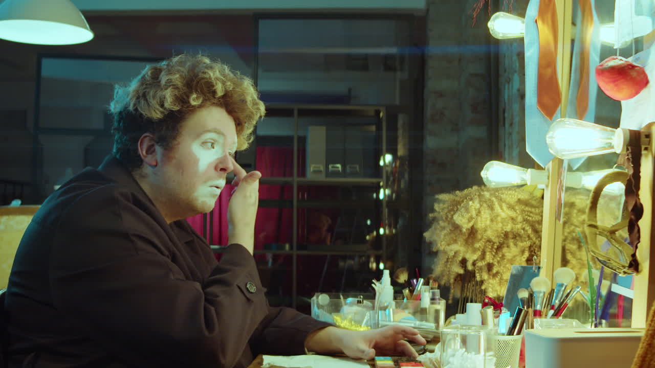 hombre haciendo maquillaje de payaso en el camerino