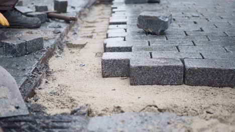 construction worker laying cobblestones