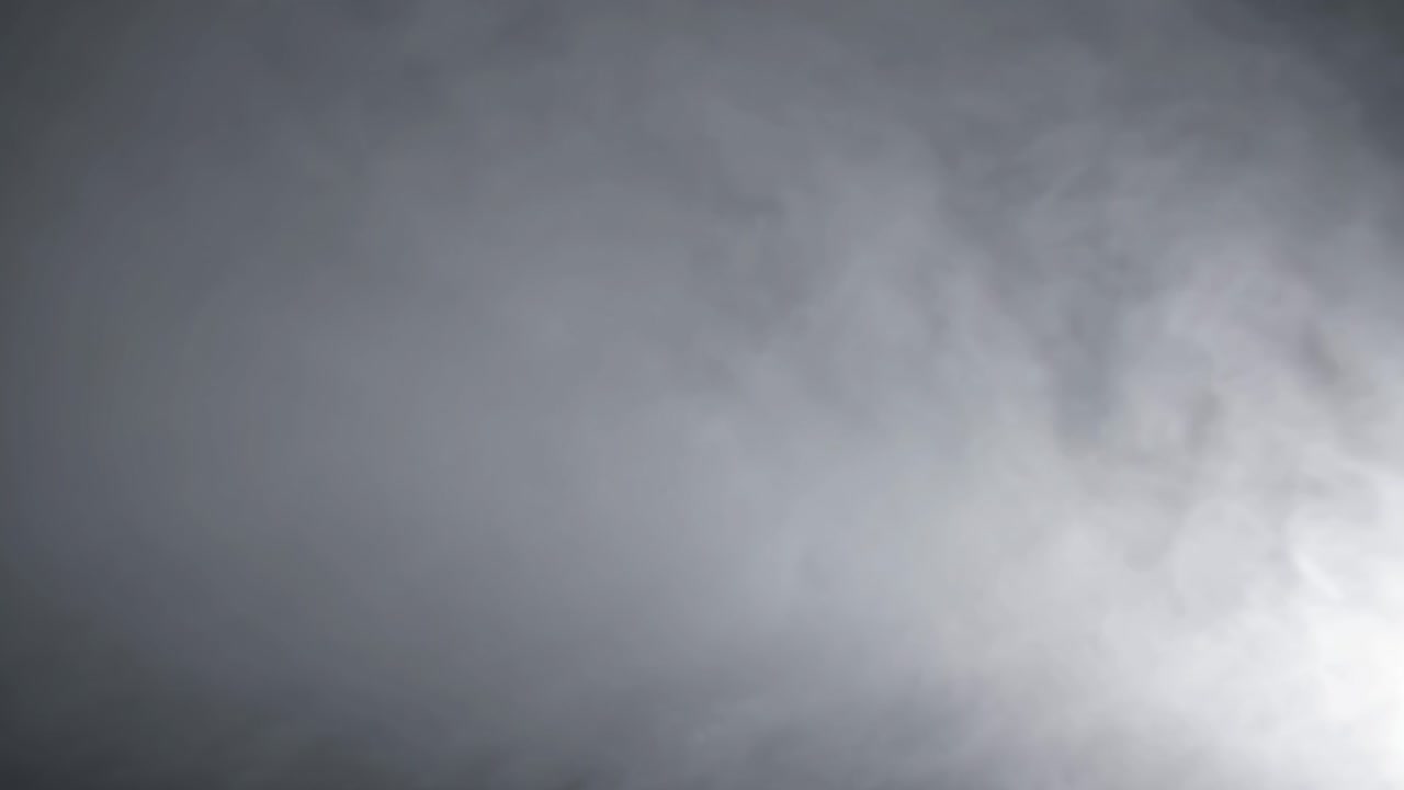 Dynamic sequence of swirling gray smoke gradually filling the frame, creating an atmospheric and moody ambiance with a sense of movement and depth