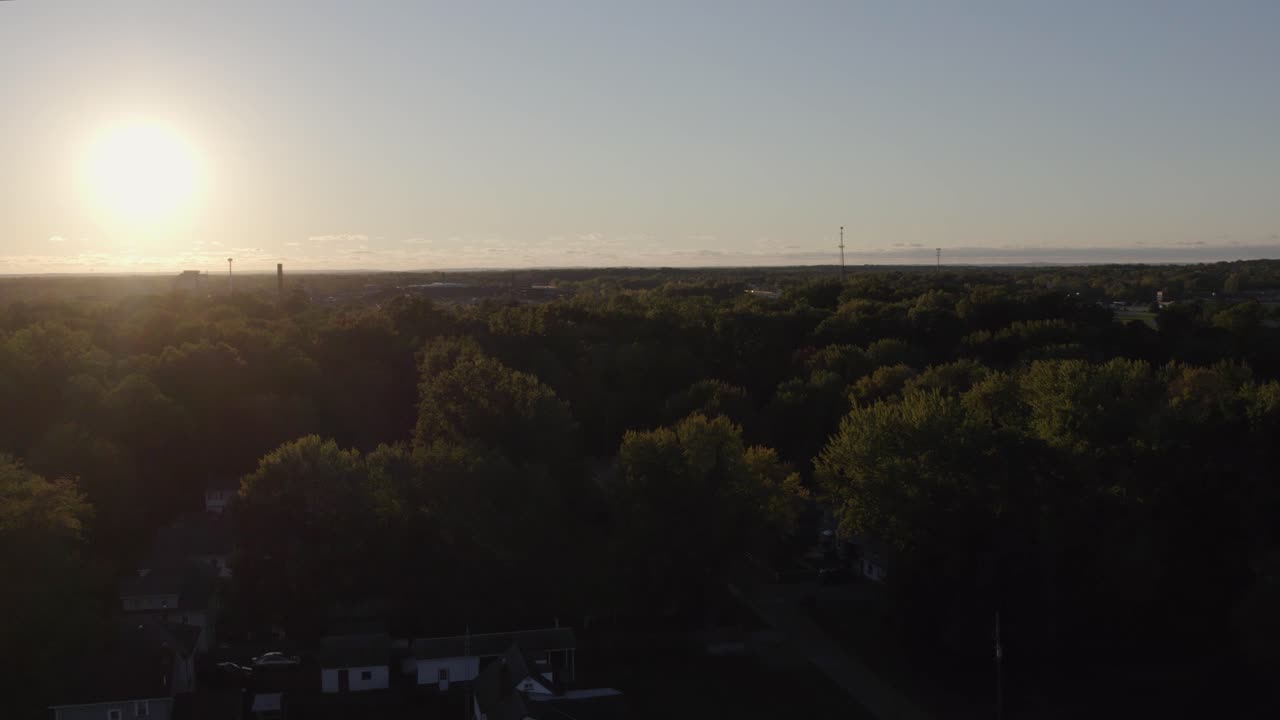 在秋天日落時,無人機在綠色密集的綠色樹木,植被和鄉村小屋上空射擊