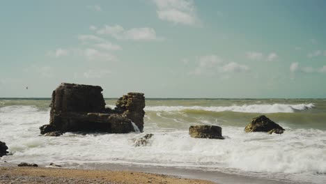 las olas del mar chocando contra las rocas en la playa
