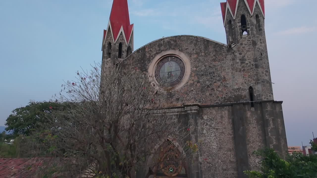 Crane up tilt down drone shot of Calvary's Church during the day in Cuernavaca, Morelos, Mexico