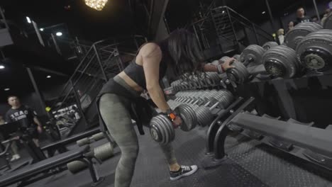 woman working out with dumbbells at the gym