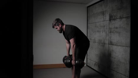 Dumbbell-Romanian-deadlift,-cinematic-lighting,-white-man-dressed-in-black-gym-attire