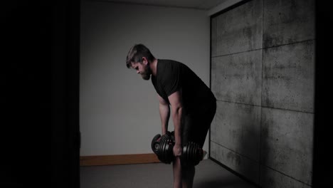 dumbbell romanian deadlift, cinematic lighting, white man dressed in black gym attire