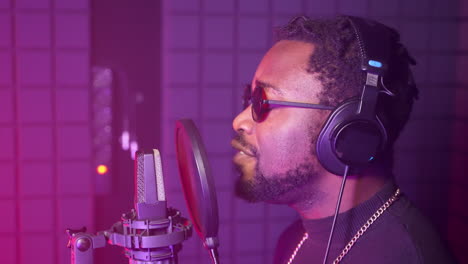 man singing into microphone in recording studio