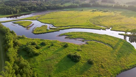 cinematic view from a drone, while rotating over a wide river that flows through green nature