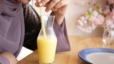 woman drinking smoothie at a restaurant