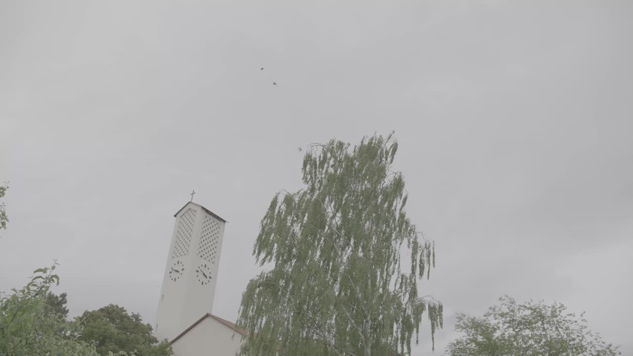 Camera pans to the Bruder Klaus Church in Gundelfingen, Germany on a windy and cloudy day