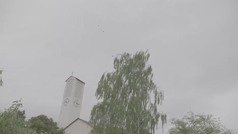 camera pans to the bruder klaus church in gundelfingen, germany on a windy and cloudy day