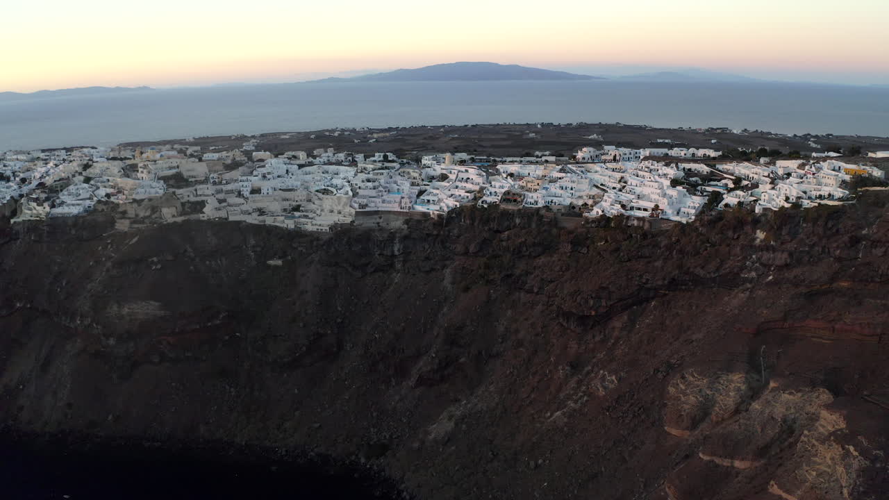 oia santorini island sunset drone shot con vistas a edificios blancos y al mar, grecia en 4k