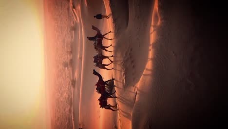 imágenes verticales de una caravana de camellos viajando a través de dunas áridas del desierto