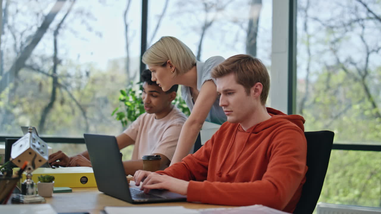 Woman mentor consulting colleague office closeup. Serious lady watching computer