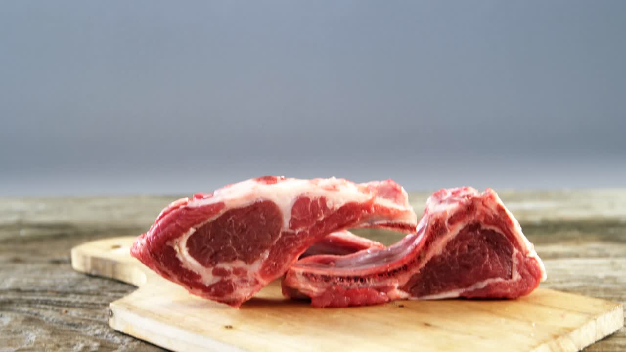 chuletas de carne cruda en tablero de madera