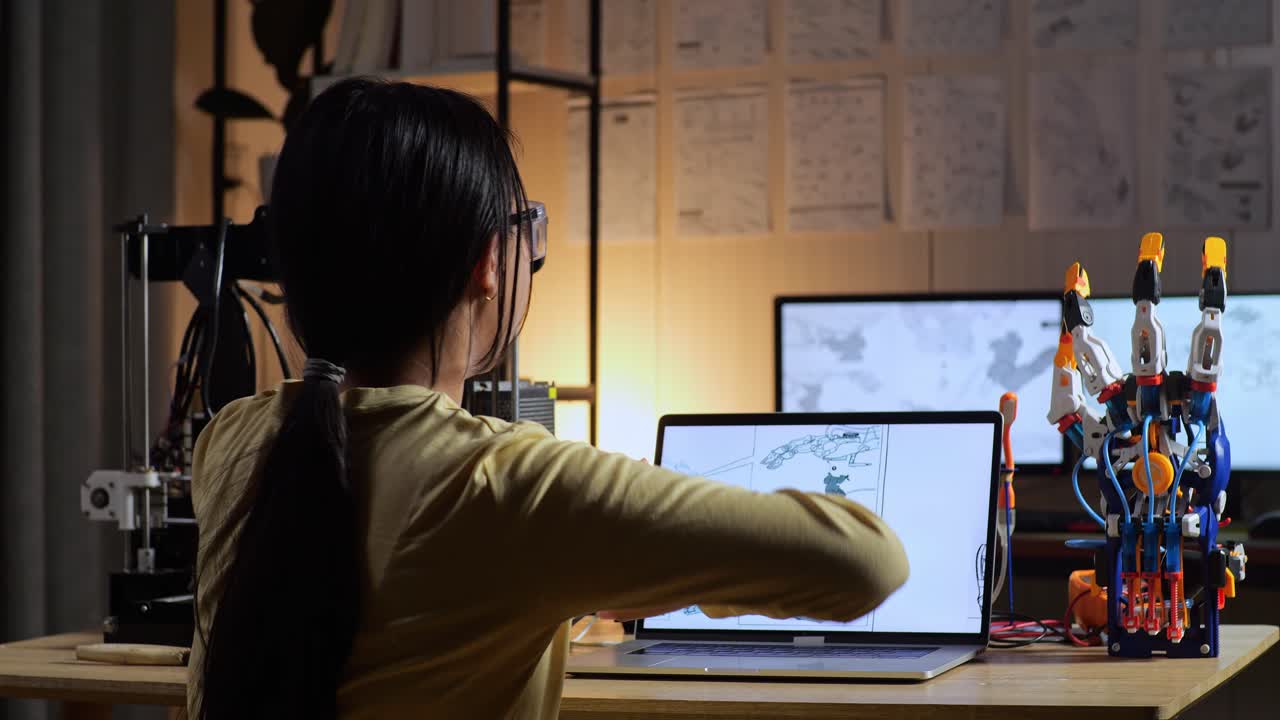 3d 프린팅으로 키보그 손을 디자인하는 십대 아시아 소녀의 뒷면