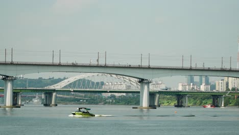 Lancha-Rápida-Y-Unidad-De-Rescate-Acuático-Lancha-Motora-Se-Mueve-Con-Velocidad-En-El-Río-Han,-Tráfico-En-El-Puente-Yanghwa-Y-El-Puente-Del-Ferrocarril-Dangsan-En-Primer-Plano,-Club-Del-Puerto-Deportivo-De-Seúl-En-Un-Día-Soleado