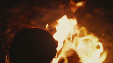 closeup shot of flames rising up from blazing bonfire in desert, slow motion