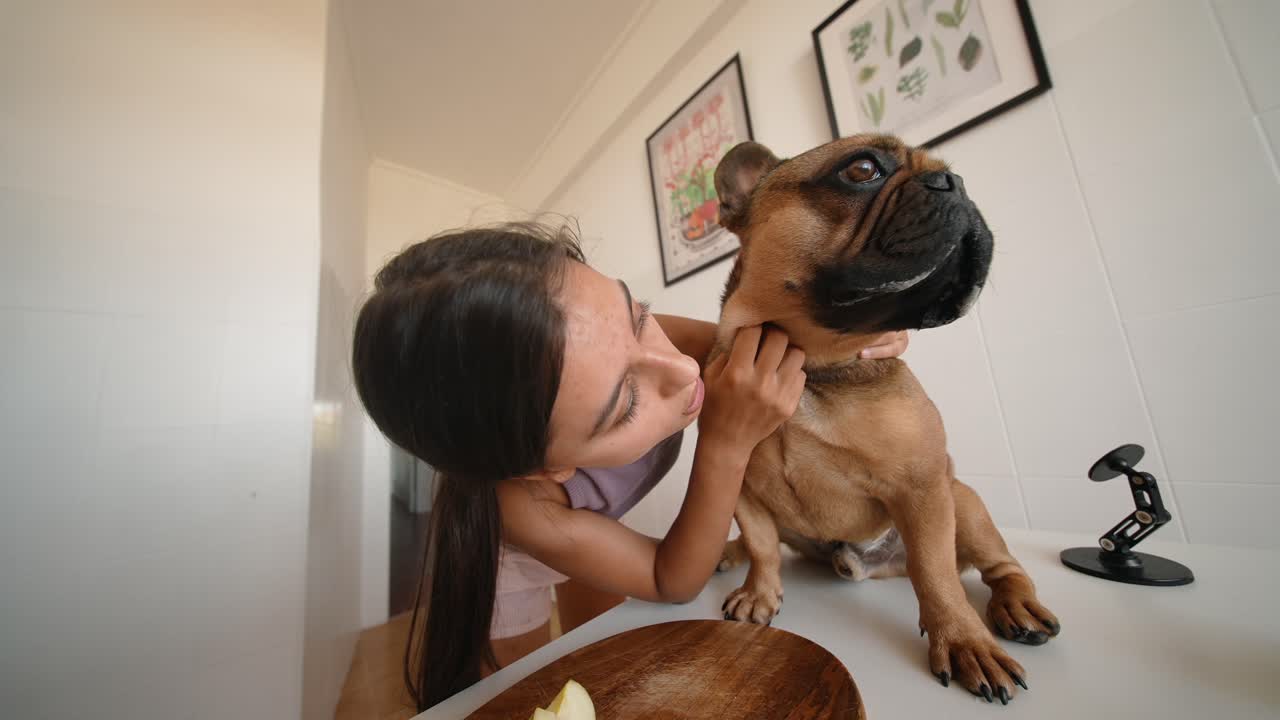 A girl hugging her dog in the kitchen