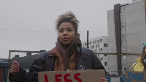 jovem ativista americana segurando um cartaz de papelão contra o uso de plásticos e protestando para salvar a terra durante um protesto contra as mudanças climáticas