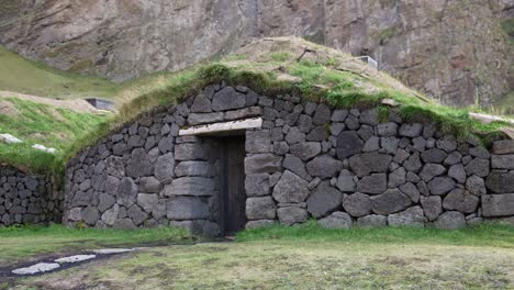 typical turf house in landscape of heimaey island, iceland