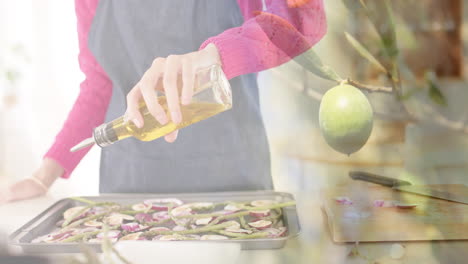 mujer biracial vertiendo aceite de oliva sobre verduras picadas en la cocina, cocinando sobre limas
