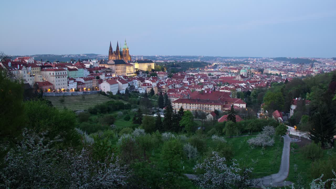 Timelapse dal giorno alla notte a Praga, Repubblica Ceca, visto dai giardini di Strahov con una vista del Castello di Praga che si illumina, Malá Strana e il centro in lontananza.