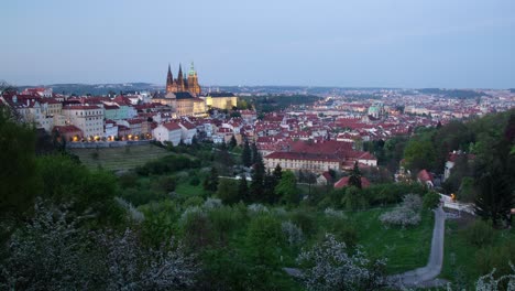 Day-to-night-timelapse-in-Prague,-Czech-Republic-as-seen-from-Strahov-gardens-with-a-view-of-Prague-Castle-lighting-up,-Malá-strana-and-downtown-in-the-distance