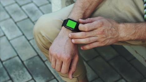 hombre con un reloj inteligente con una pantalla verde