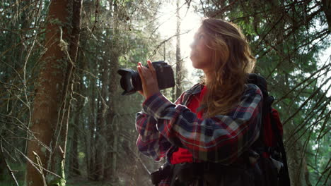 Woman-taking-photos-on-camera-in-forest.-Tourist-adjusting-zoom-on-camera-lens