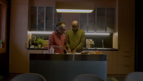una pareja madura jugando en la cocina.