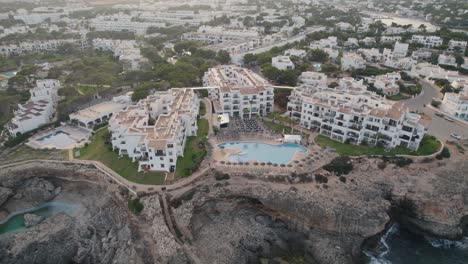 Establecimiento-De-Una-Vista-Aérea-Que-Se-Eleva-Desde-Un-Complejo-De-Vacaciones-En-El-Borde-Del-Acantilado-Costero-De-Mallorca