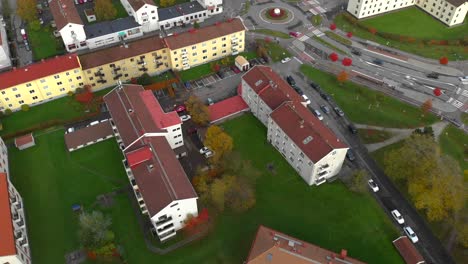 aerial view over a city with building rooftops near the main road with cars passing by, modern city concept, looking down shot