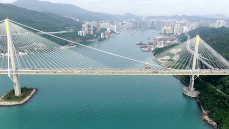 traffic on a bridge in hong kong bay with city buildings in the horizon, aerial view