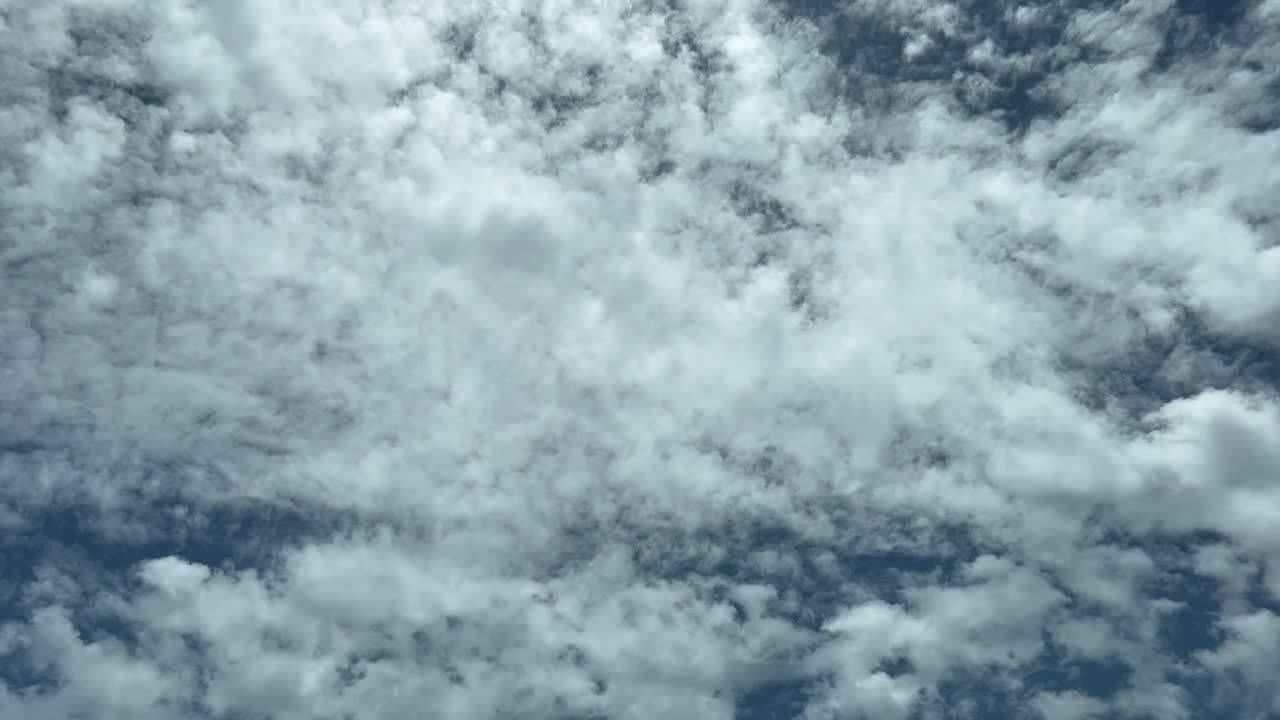 punto de vista único del piloto mientras vuela por debajo de algunas nubes dispersas en diversas altitudes y capas